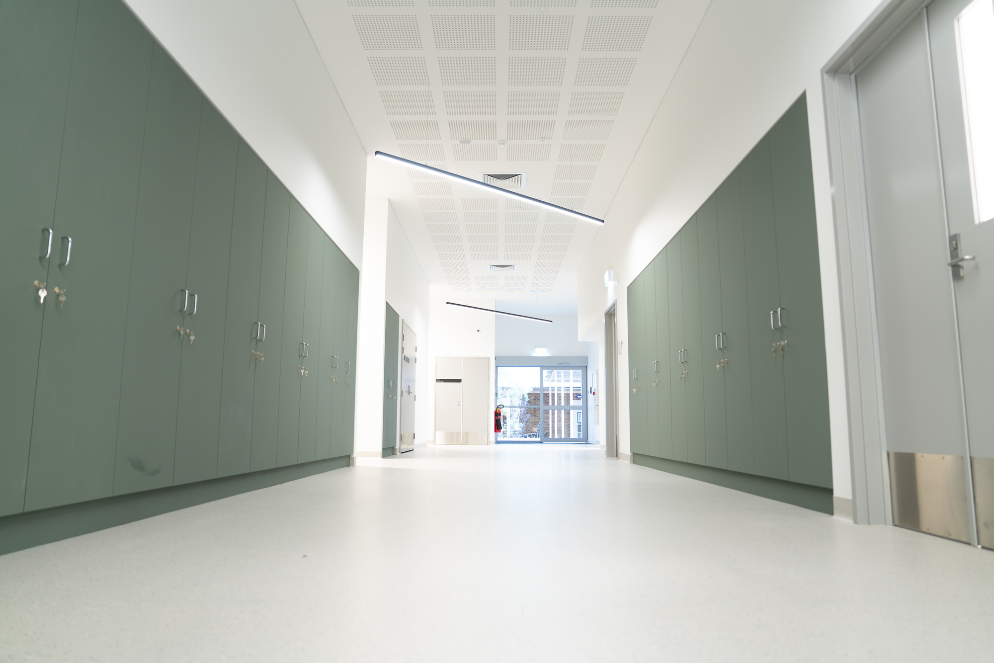 Refurbished clinical corridor at ECU Bunbury campus with built-in storage cabinets and modern ceiling lighting.